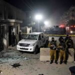 "Crime scene aftermath of the Gulistan-e-Jauhar Rangers attack in Karachi, showing damaged gate, destroyed vehicle, heavy security, and police presence."