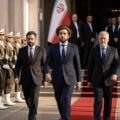"Ahmad Massoud and the National Resistance Front (NRF) delegation walking on a red carpet at an official government reception in Tehran, flanked by Iranian honor guards."
