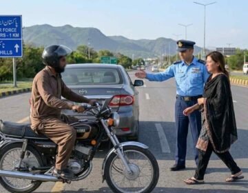 Alt Text: A PAF officer in uniform signaling a distressed woman to safety on an Islamabad highway with a motorcyclist nearby and Margalla Hills in the background.
