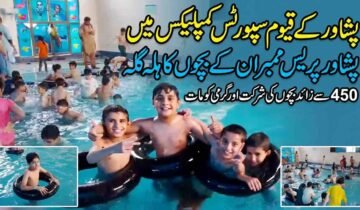 A composite photo of a children's swimming event at an indoor pool. The main section shows happy boys posing in black inner tubes. A large headline in Urdu at the top reads: "In Peshawar's Qayyum Sports Complex: Fun for Peshawar Press Members' Children." Subtext states: "Over 450 children participate and beat the heat." Two small inset photos show more pool activity.