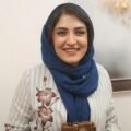 Iranian photojournalist Yalda Moaiery smiling in a navy blue scarf