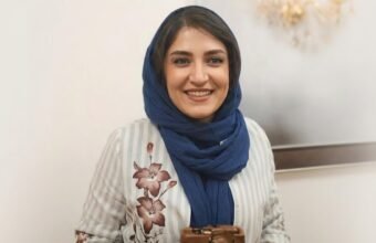 Iranian photojournalist Yalda Moaiery smiling in a navy blue scarf