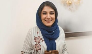 Iranian photojournalist Yalda Moaiery smiling in a navy blue scarf