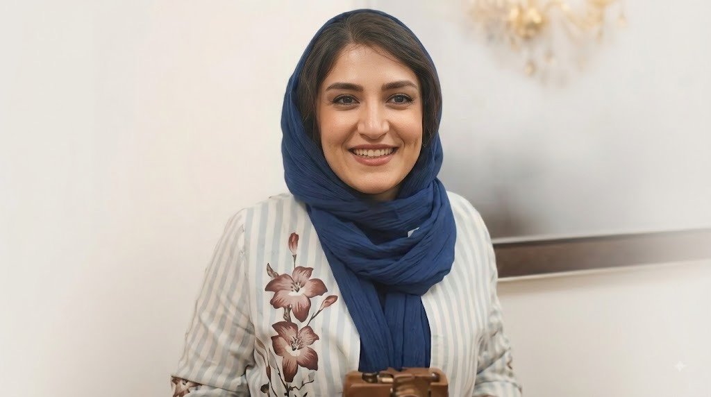 Iranian photojournalist Yalda Moaiery smiling in a navy blue scarf