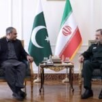 Pakistan Interior Minister Mohsin Naqvi meeting Iranian SNSC Secretary Mohsin Rezaei in Tehran with Pakistani and Iranian flags in the background