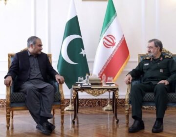 Pakistan Interior Minister Mohsin Naqvi meeting Iranian SNSC Secretary Mohsin Rezaei in Tehran with Pakistani and Iranian flags in the background
