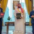 Turkish President Erdogan, Saudi Crown Prince MBS, and PM Shehbaz Sharif holding signed Pakistan Saudi Turkey defense agreement documents.