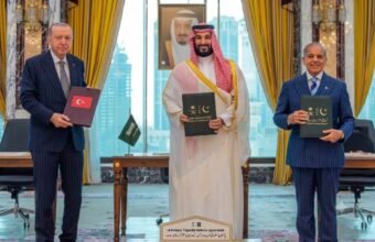 Turkish President Erdogan, Saudi Crown Prince MBS, and PM Shehbaz Sharif holding signed Pakistan Saudi Turkey defense agreement documents.