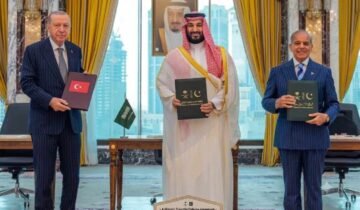 Turkish President Erdogan, Saudi Crown Prince MBS, and PM Shehbaz Sharif holding signed Pakistan Saudi Turkey defense agreement documents.