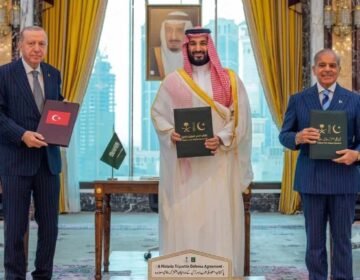 Turkish President Erdogan, Saudi Crown Prince MBS, and PM Shehbaz Sharif holding signed Pakistan Saudi Turkey defense agreement documents.