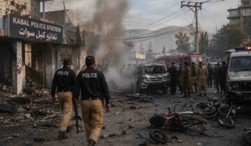 Police and rescue teams respond after a suicide attack at Kabal Police Station in Swat, with smoke, damaged vehicles, and debris visible.