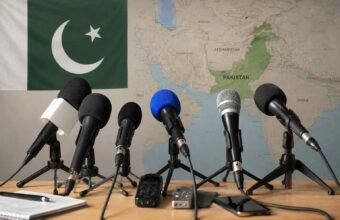 Microphones in a press briefing setup with the Pakistan flag and a map of Pakistan in the background
