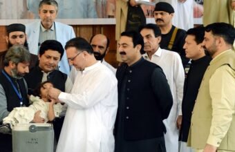KP Health Minister Khaliq-ur-Rehman administering polio drops to a child to inaugurate the anti-polio campaign at Services Hospital, Peshawar.