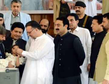 KP Health Minister Khaliq-ur-Rehman administering polio drops to a child to inaugurate the anti-polio campaign at Services Hospital, Peshawar.