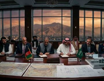 A high-level signing ceremony in a Kabul conference room with Afghan and Saudi delegates seated at a mahogany table displaying energy blueprints, maps, and model pipelines against a backdrop of mountains at sunset.
