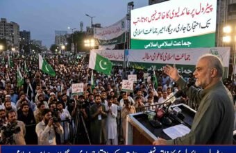 Jamaat-e-Islami Chief Hafiz Naeem ur Rehman addressing a massive public protest rally against petroleum levy with banners and crowd holding party flags in the background.