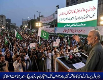 Jamaat-e-Islami Chief Hafiz Naeem ur Rehman addressing a massive public protest rally against petroleum levy with banners and crowd holding party flags in the background.