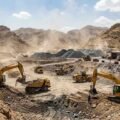 Heavy machinery, excavators, and trucks operating at an open-cast mining site in Khyber Pakhtunkhwa.