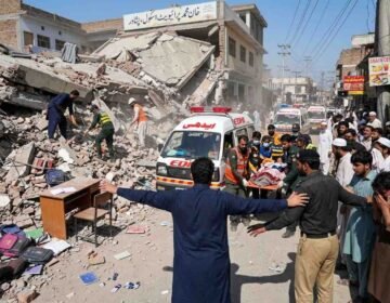 Rescue workers and Edhi ambulance at the collapsed private school building site in Dir Colony, Peshawar.