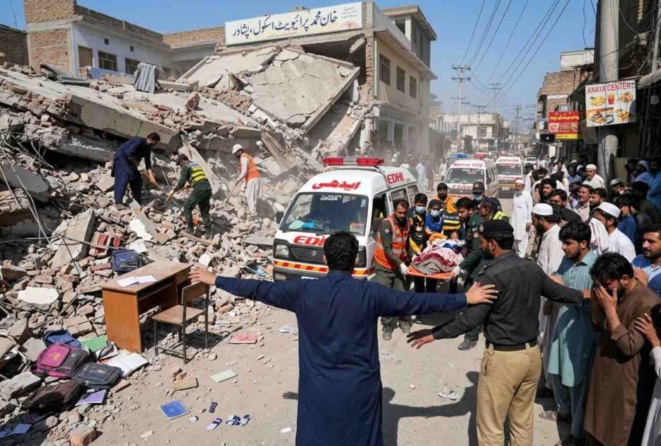 Rescue workers and Edhi ambulance at the collapsed private school building site in Dir Colony, Peshawar.